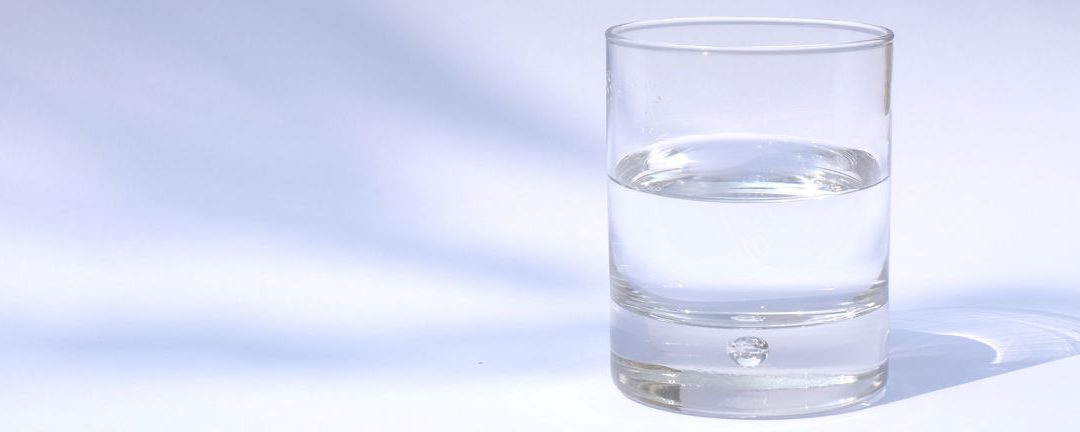 A glass of clear water on a simple background